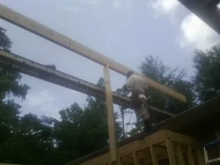 Carpenter setting a ridge beam over a new addition frame — Ice Dam Removal by Roofing Brothers in Hamden